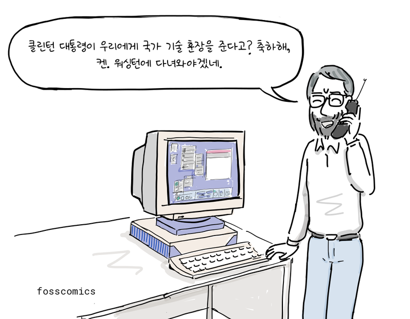 컴퓨터 옆에 서서 전화를 받는 리치.